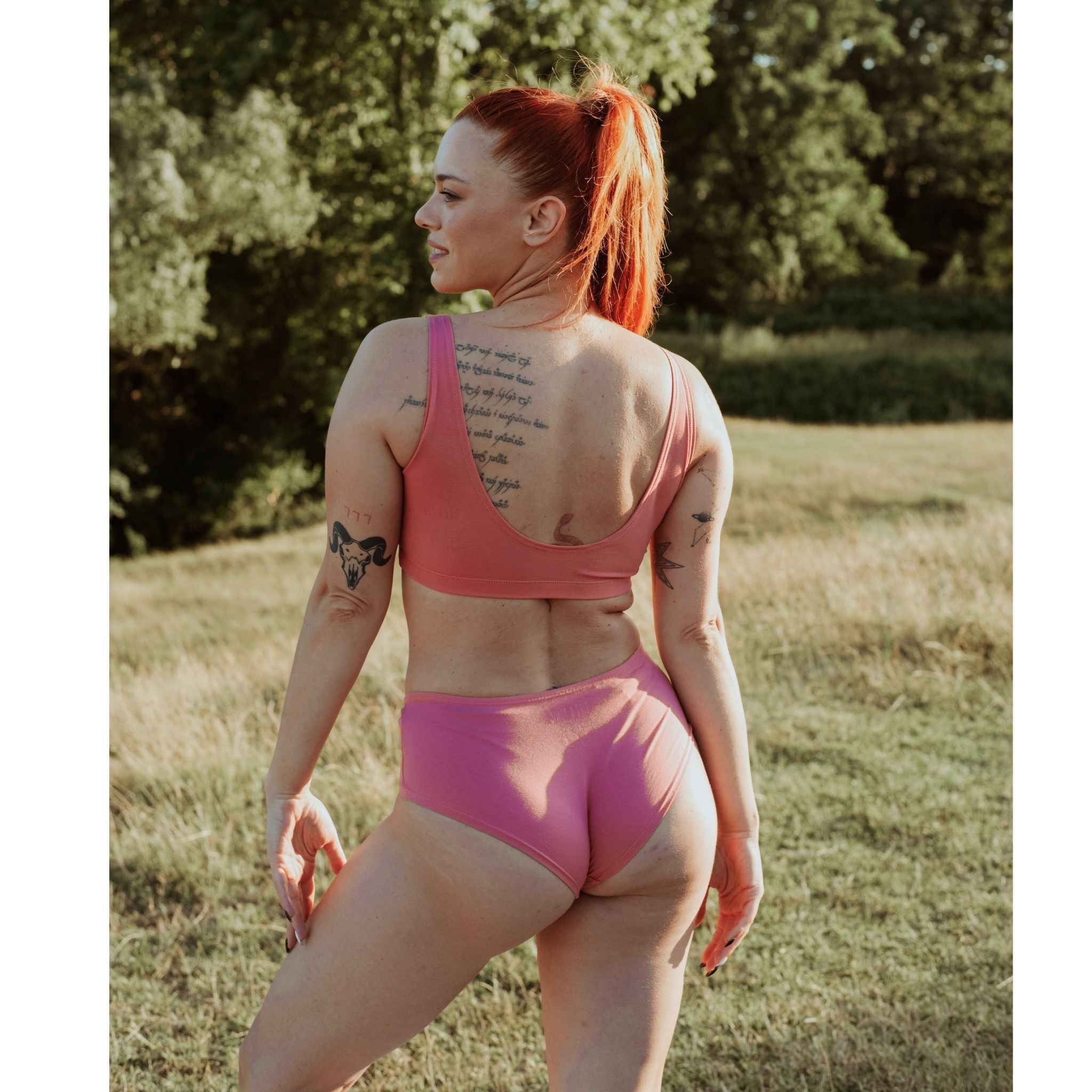 Woman wearing Desert Rose Organic Cotton Hipster Panty in a sunlit outdoor setting.