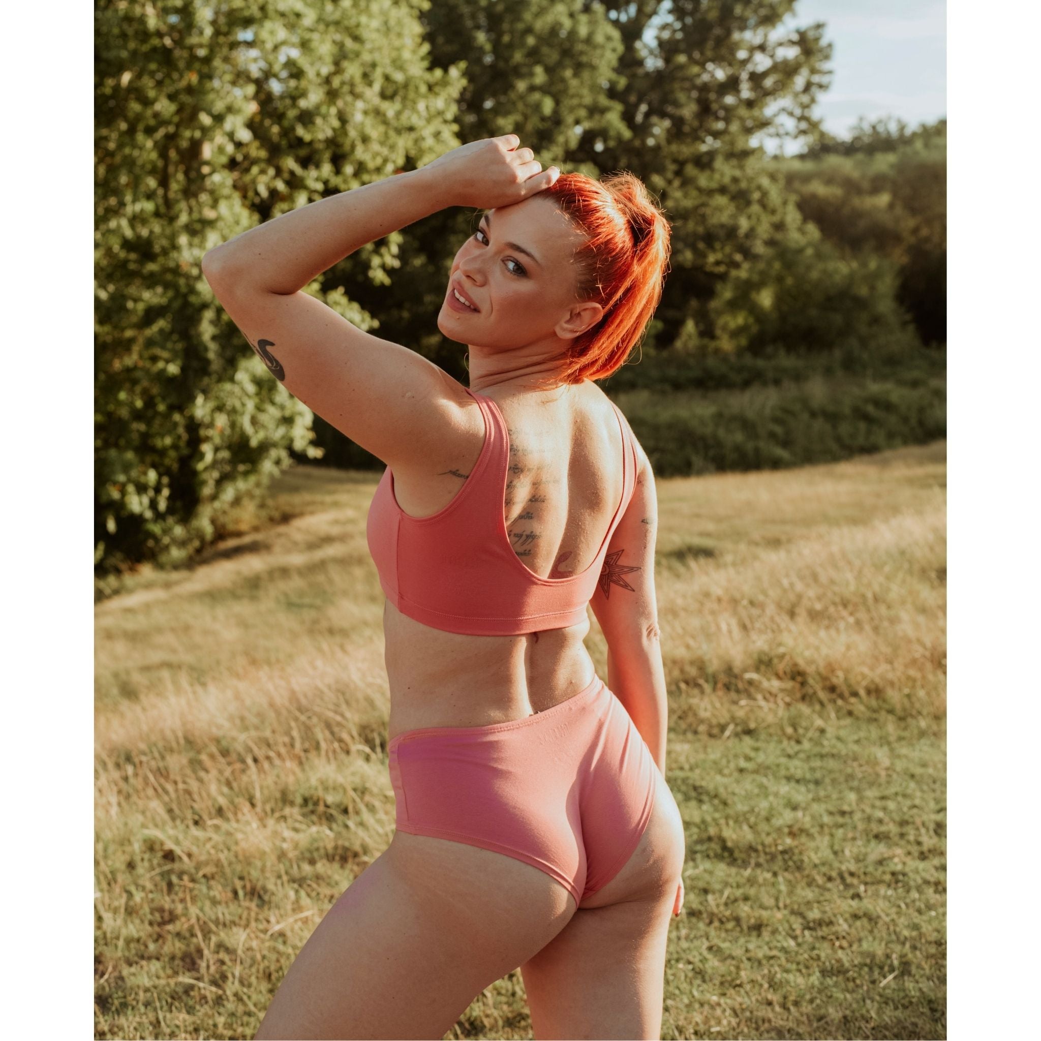 Woman wearing Desert Rose Organic Cotton Hipster Panty in a sunlit outdoor setting.
